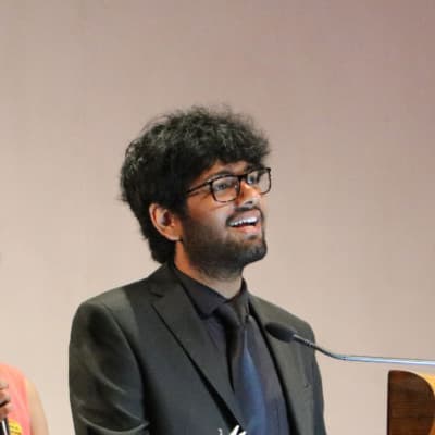 Abhishek Ajay speaking at a lectern